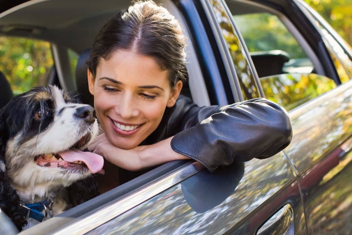 Woman in car with dog is happy after pet proofing her car