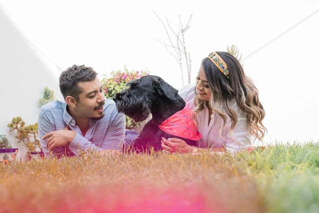 a couple with their adopted dog enjoy being a pet parents