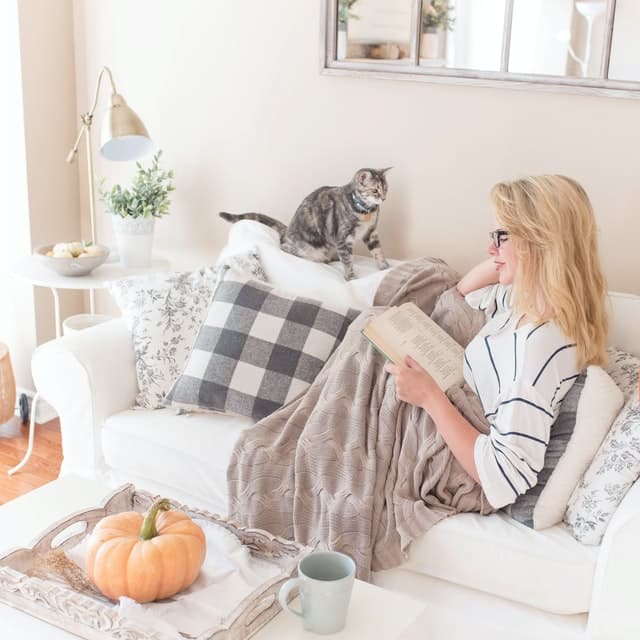 blonde woman reading with her cat on national cat day