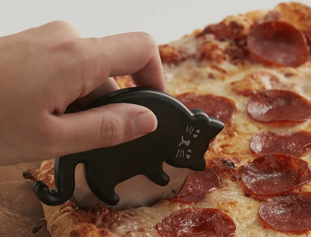 A person holding a pizza cutter with a cat on it is the perfect gift for cat lovers.