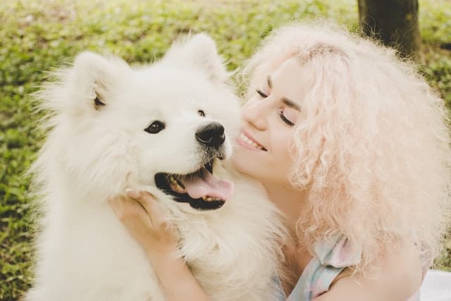 A woman and a dog. She may want dog and cat health insurance or multi pet insurance