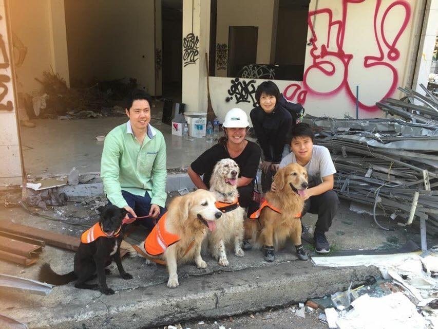 Dog trainer Maria Alojaman poses with dogs and pet owners