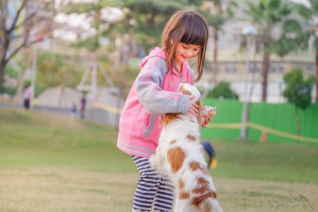 little girl pats a puppy as a random act of kindness