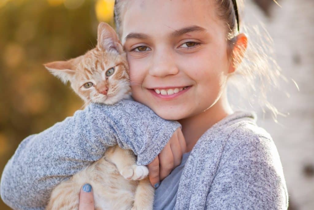 Girl receives an adopted kitten from mum and dad on Random Acts of Kindness Day
