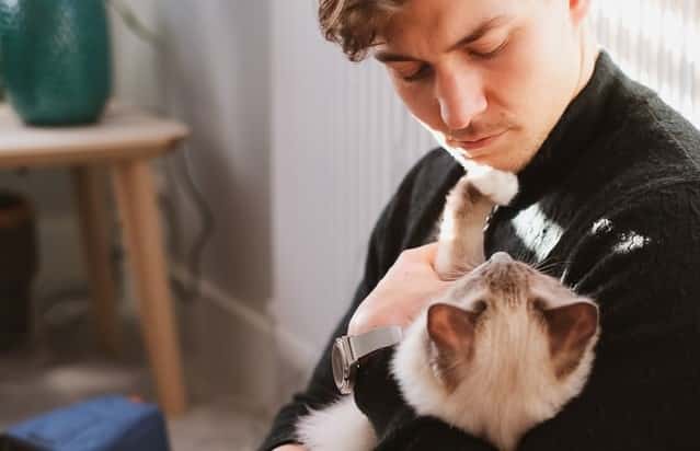 a crazy cat lad holds his cat