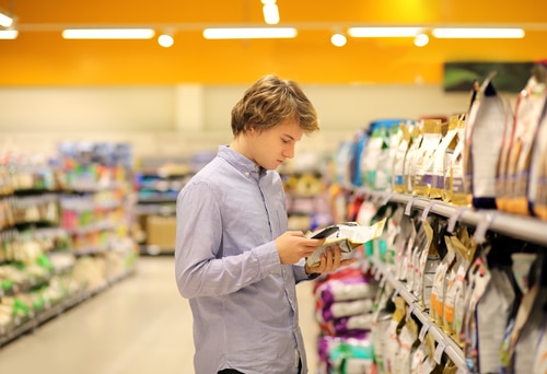 a customer looks at Royal Canin and Purina pet food packaging and tries to understand global pet food guidelines