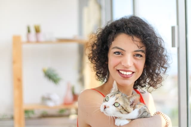 A woman holding a cat and thinking of insurance industry news and insurance trends in 2023 