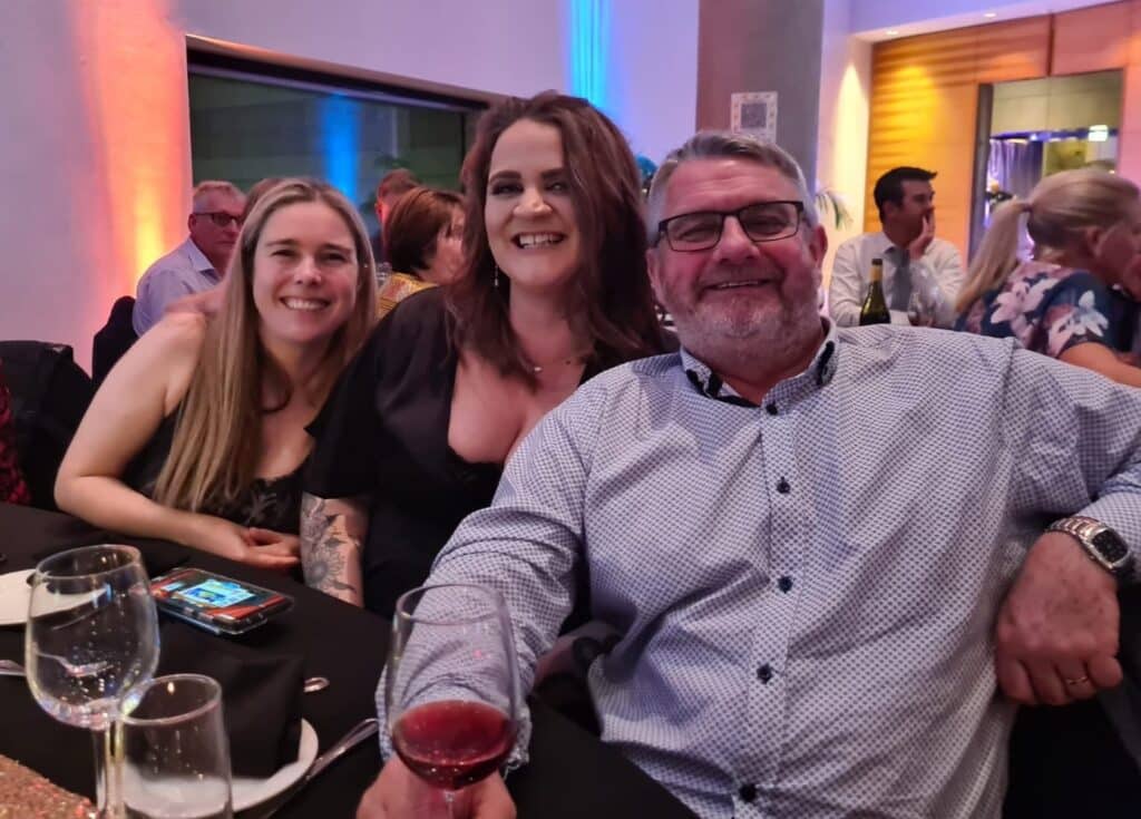 Rhea (left) and Steve (right) from Dogs New Zealand sit with Sally (center) who represented the Healthy Pets New Zealand exhibit.