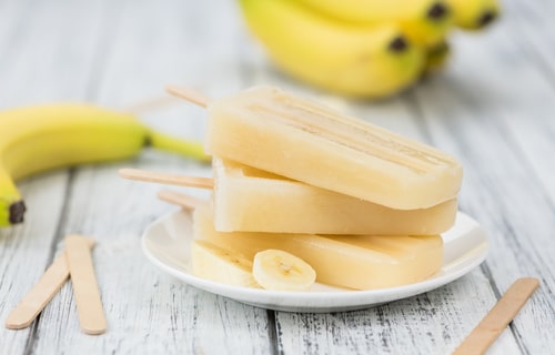 Homemade Banana Popsicles on a vintage background