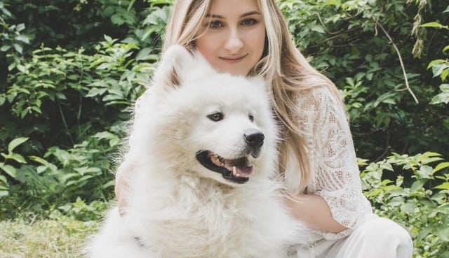 A woman with a white samoyed dog named Bella - one of the top dog names in New Zealand