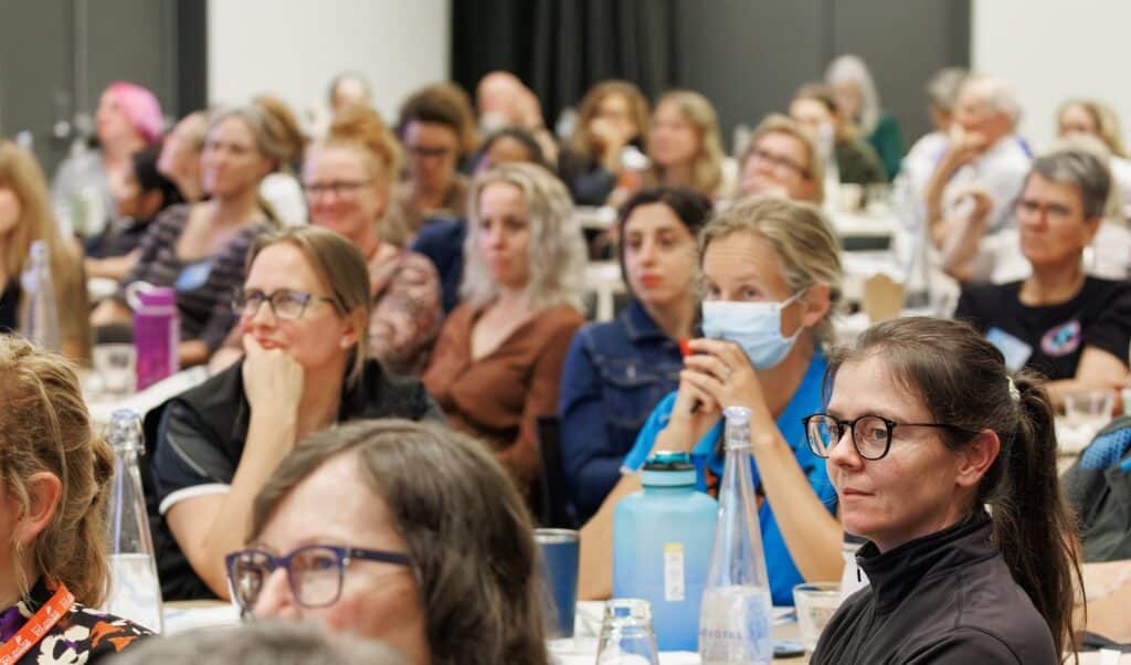 Attendees listening intently at the CANZ conference event.