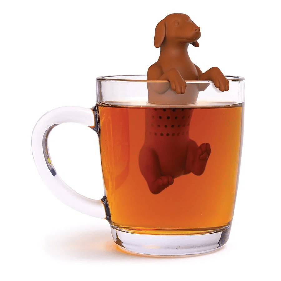 A clear glass mug filled with tea, featuring a brown tea infuser shaped like a dog sitting on the rim—perfect as a quirky Father’s Day NZ gift or for any cat dad looking to spice up their brew.