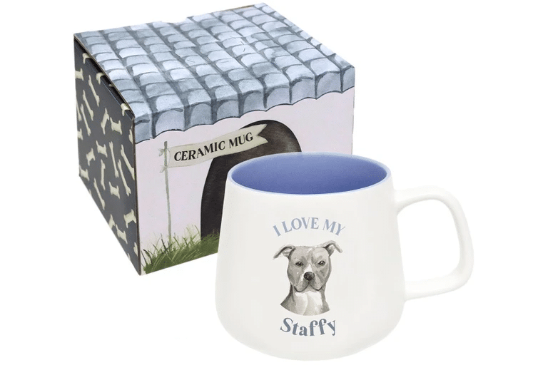A white ceramic mug with a blue interior features a Staffordshire Bull Terrier and the text "I LOVE MY Staffy." Perfect for dog dad gifts or as a thoughtful Fathers Day gift, it comes beside a box with a charming doghouse design.