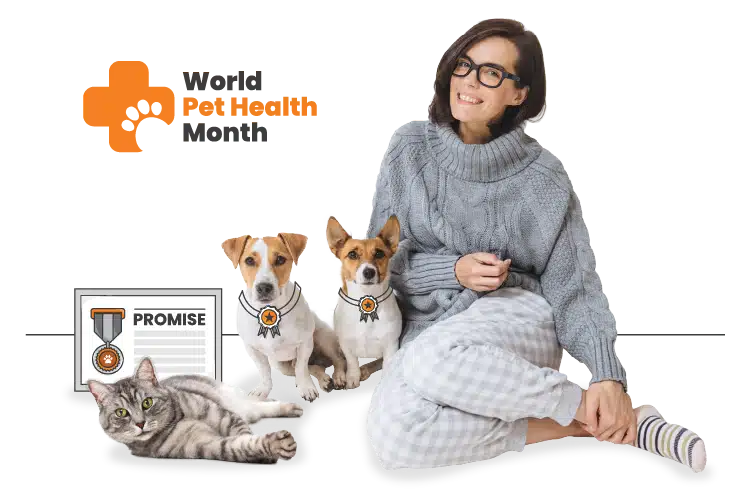 A woman in glasses and pajamas sits on the floor with two small dogs wearing medals and a gray cat beside a "PROMISE" certificate—you've joined the WPHM movement and are celebrating World Pet Health Month together.